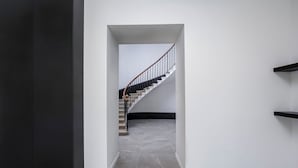 A modern interior with a marble staircase, white walls, and black shelves. - Château de la Roche (Vourles)