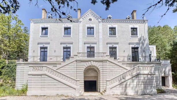 A large, two-story building with a symmetrical facade, a central entrance with a decorative arch, and a set of stairs leading to the main entrance. - Château de la Roche (Vourles)