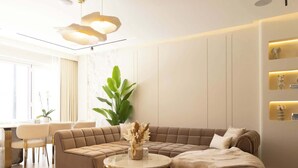 Ein modernes Wohnzimmer mit einem Ecksofa, einem runden Couchtisch und einer großen Zimmerpflanze.