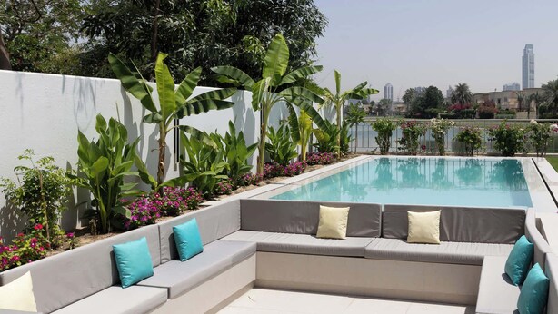 A poolside area with a large, modern sectional sofa and a pool. - Villa Zalex Springs 14 Luxury Living with Private Pool (Dubai)