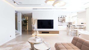 A modern living room with a flat-screen TV, a marble coffee table, and a beige sofa. - Villa Zalex Springs 14 Luxury Living with Private Pool (Dubai)