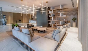 Relax in the stylish lobby with a comfortable sofa, coffee table, and bookshelf.