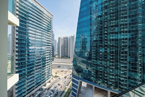 Standing tall in the heart of the city, this sleek high-rise building boasts a striking glass facade with a unique architectural design.