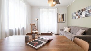 A modern living room with a wooden dining table, a grey sofa, and a floor lamp. - Italianway Easy - Palazzi 6 C (Milan)