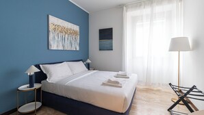 A modern hotel room with a large bed, two bedside tables, a floor lamp, and artwork on the walls. - Italianway Easy - Palazzi 6 C (Milan)