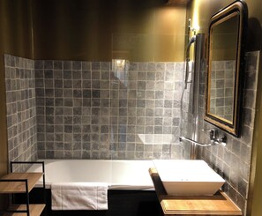 A bathroom with a bathtub, a sink, and a mirror. - Domaine du Très-Haut  (Montanges)