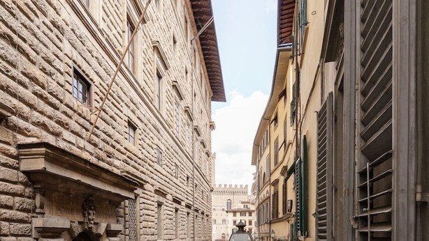 A narrow street with stone buildings, a pedestrian walkway, and a metal railing. - Uffizi & Palace View - Florence Dolce Vita (Firenze)