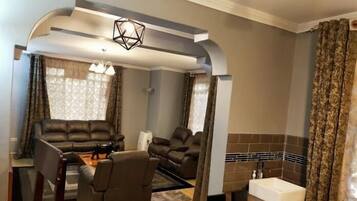 Familienbungalow, Gartenblick | Wohnbereich | 24-Zoll-Fernseher mit Digitalempfang