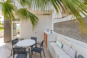 A modern outdoor patio with a round table, chairs, a sofa, and a cabinet. - FLH Funchal Terrace Studio (Funchal)