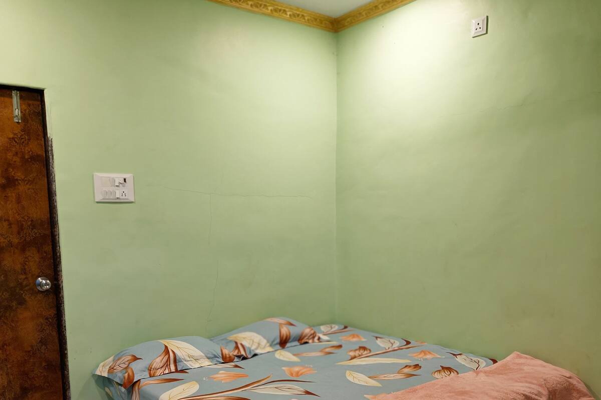 A bedroom with a bed, a ceiling fan, and a door.