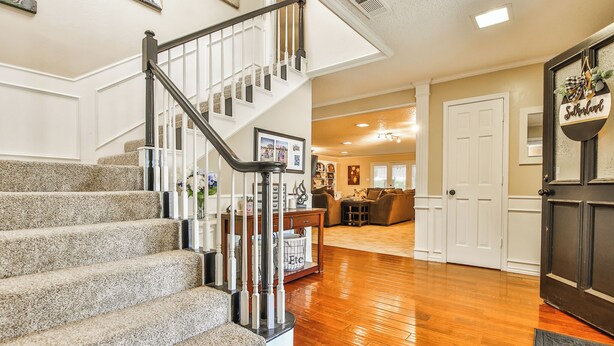 A staircase with a handrail, carpeted steps, and a door with a sign. - Amazing 4,500 sq ft 2-story home in King's Gate. Perfect for large groups! (Lubbock)