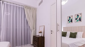 Une chambre à coucher avec un lit, une commode et une porte.