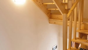 A wooden staircase with a light fixture above it. - Alborghetto2 (Gerace)