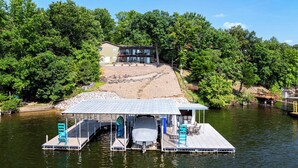 A dock with a covered seating area and a covered boat storage. - Lakeside Oasis Room for 12! (Linn Creek)