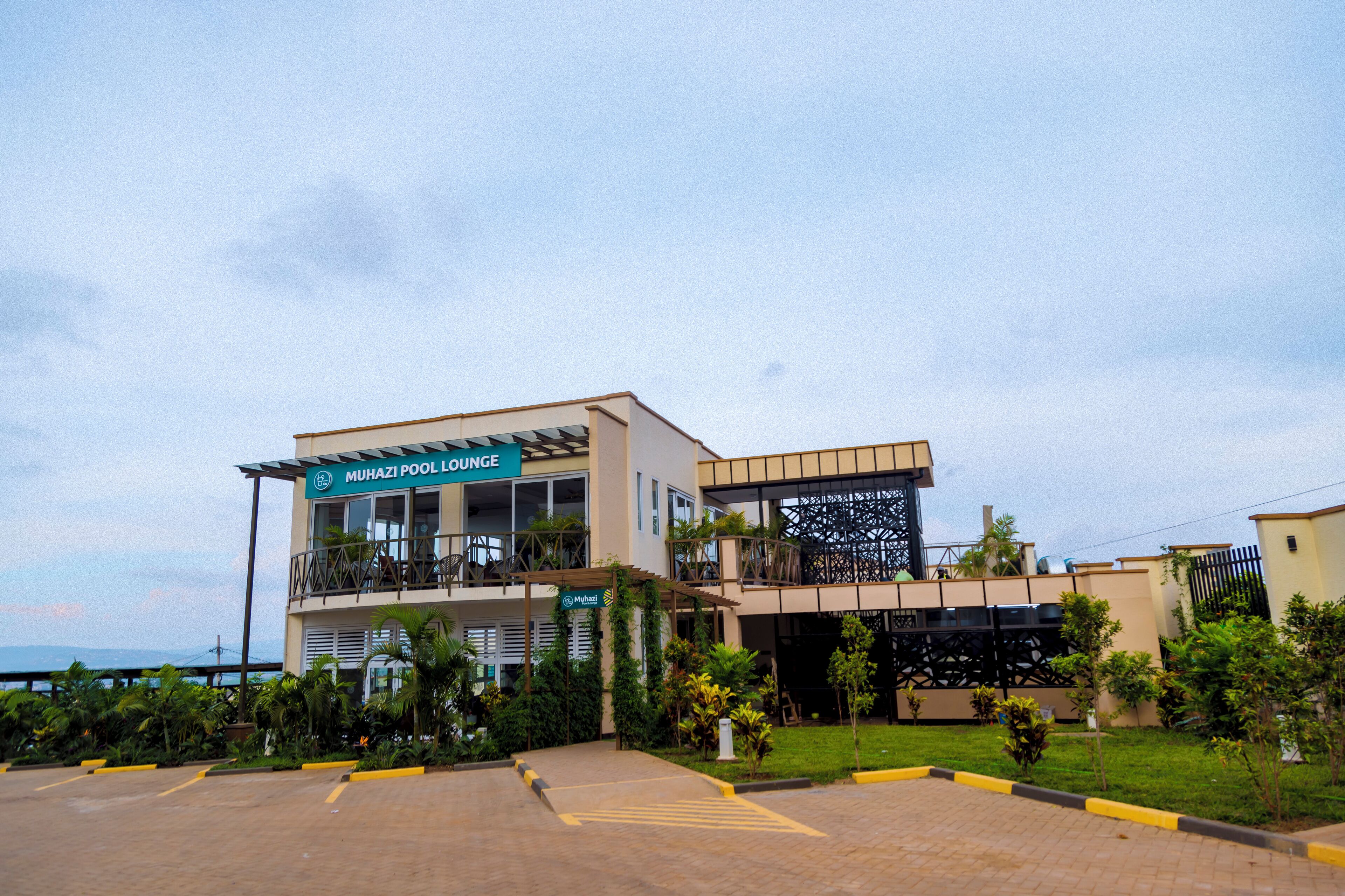 Un edificio moderno con un letrero que dice "MUHAZI POOL LOUNGE".