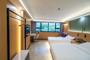Une chambre d’hôtel avec deux lits, un bureau, une chaise et une armoire.