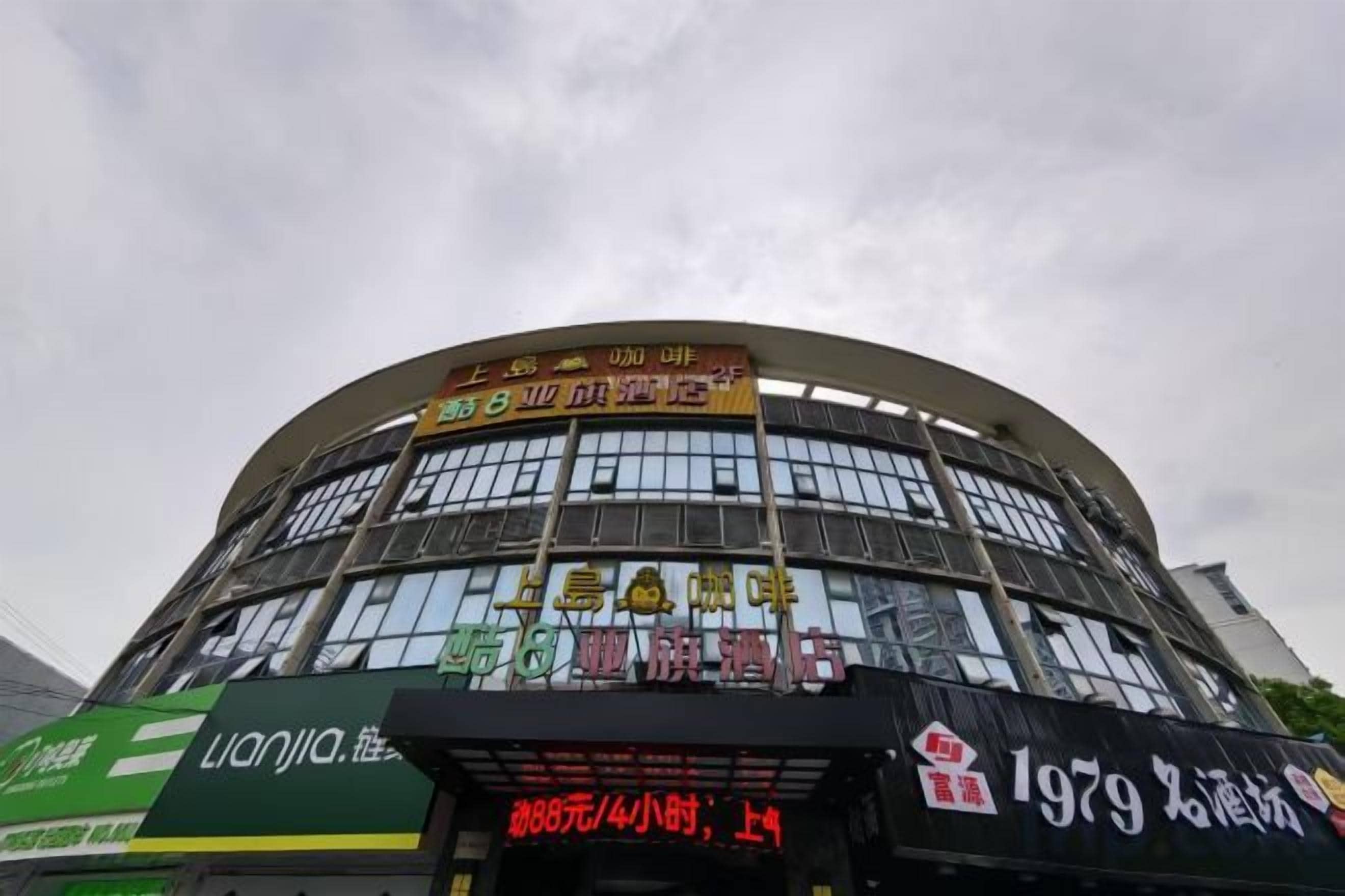 A multi-story building with signage indicating a restaurant and a shop on the ground floor.