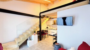 Un intérieur moderne avec un escalier en bois, un coin repas et une cuisine.