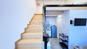 Un intérieur moderne avec un escalier en bois menant à un espace cuisine.