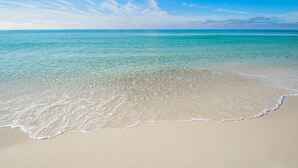 A beach with clear turquoise water and a sandy shore. - Sterling Shores 616 (Destin)
