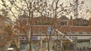 Une vue de rue avec des immeubles, des voitures garées et des piétons.
