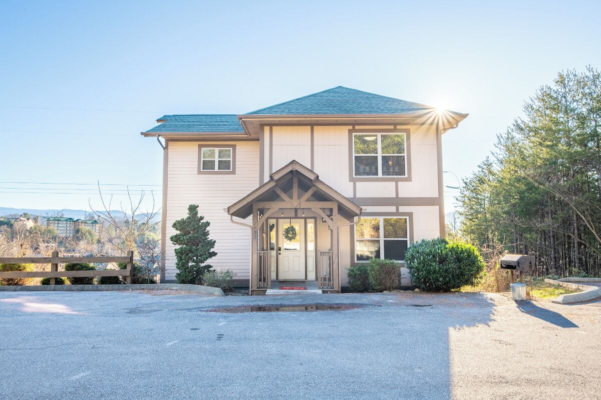 A two-story house with a front porch, a garage, and a driveway.