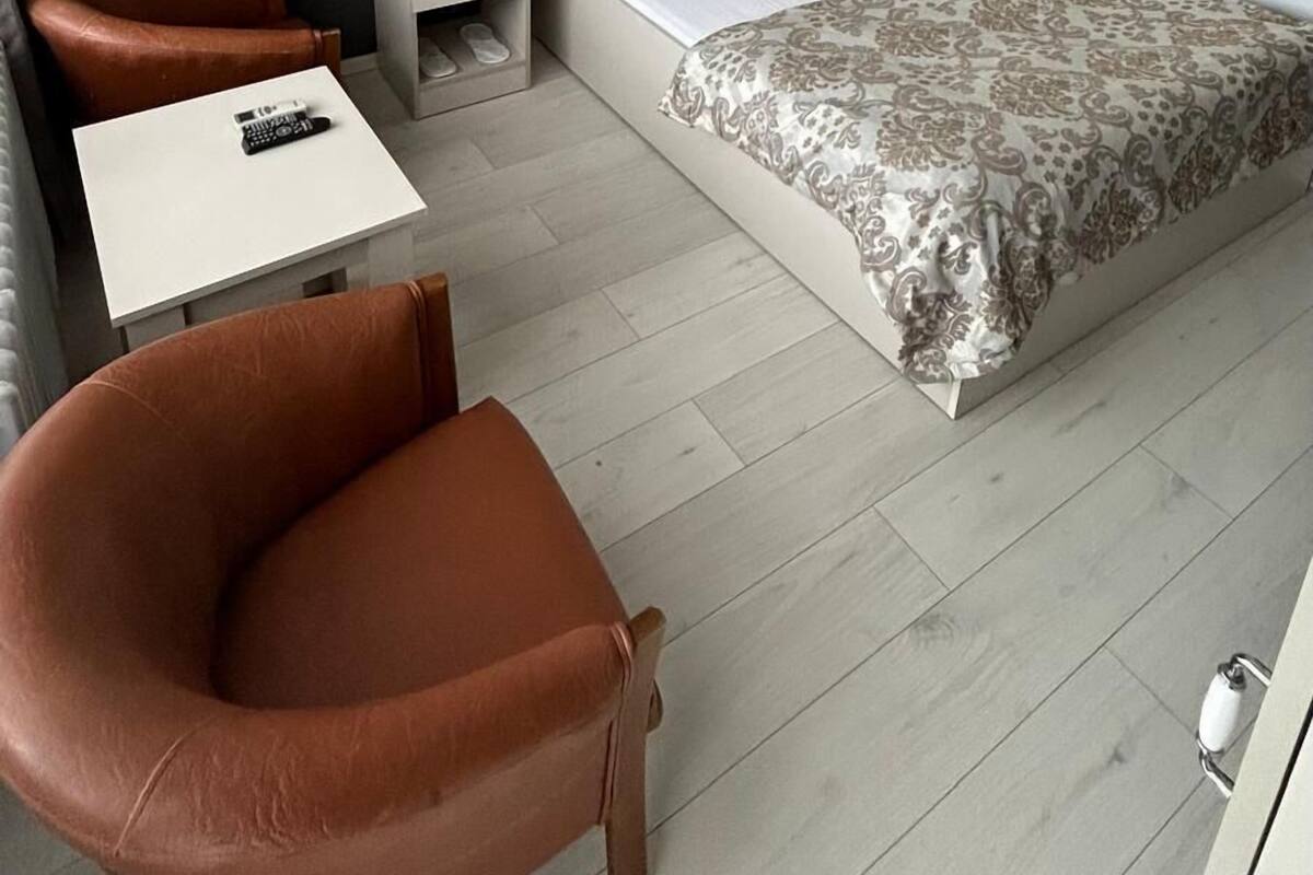 A hotel room with a bed, a desk, a chair, and a nightstand.