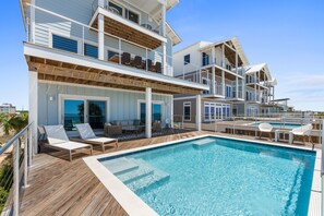 A multi-story building with a swimming pool, outdoor seating, and balconies.