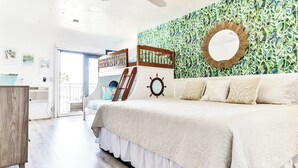 Een slaapkamer met een stapelbed, een grote spiegel en een muur in nautische stijl.