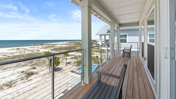 A wooden deck with a view of the beach and ocean, a pool, and a covered area with chairs. - Daiquiri: Beachfront in Mexico Beach, Private Pool, Pet Friendly (Mexico Beach)