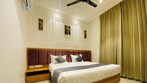 A modern bedroom with a large bed, wooden headboard, and a nightstand. - Hotel MJ MARRIOTS (Amritsar)