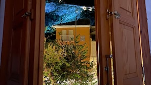 Eine Küche mit Holzausstattung, einem Spülbecken und einem Fenster mit geöffnetem Klappladen.