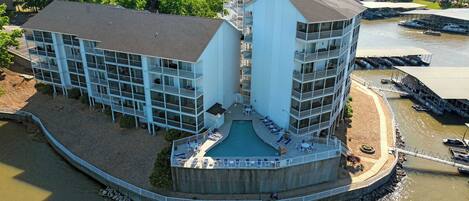 A multi-story hotel with a central courtyard, balconies, and a pool.