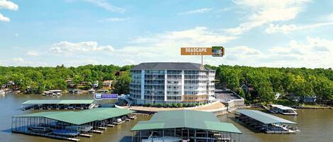 A multi-story building with a swimming pool and docked boats.