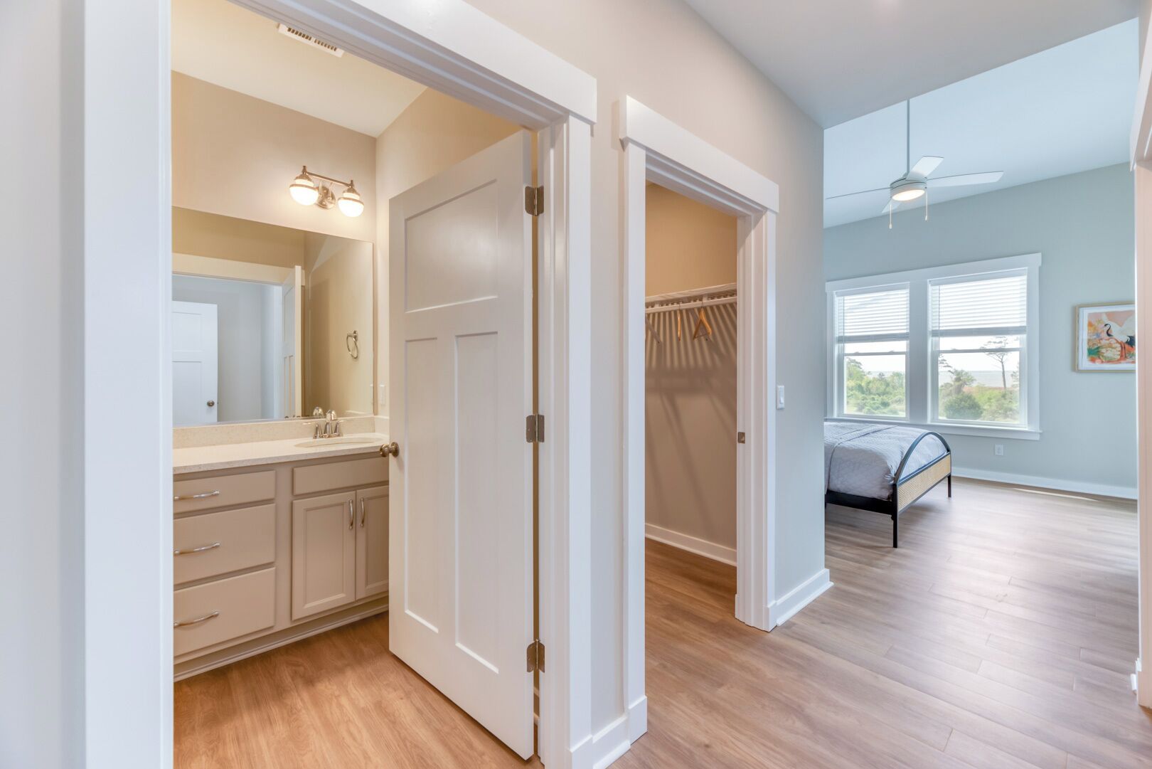 A bedroom with a bed, a window, and a closet with a hanging rack.