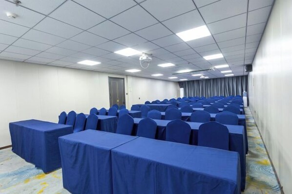A conference room with rows of tables and chairs, a projector, and a door. - ning zhao Hotel (Shijiazhuang Railway University Subway Station) (Shijiazhuang)