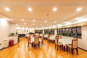A spacious dining area with multiple tables and chairs, a counter, and a tiled floor. - ning zhao Hotel (Shijiazhuang Railway University Subway Station) (Shijiazhuang)
