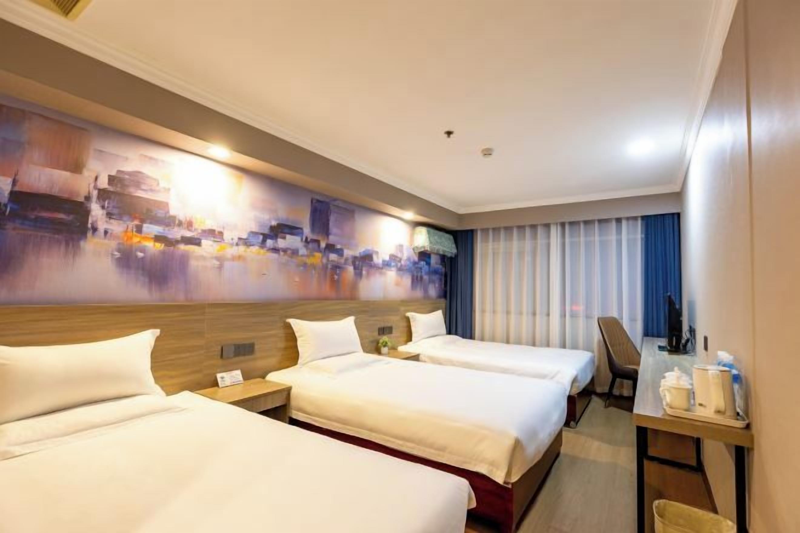 A hotel room with two beds, a desk, and a large abstract painting on the wall.