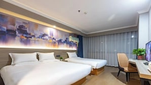 A hotel room with two beds, a desk, a chair, and a large abstract painting on the wall.