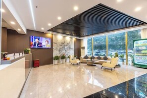 A hotel reception area with a TV, seating, and a refrigerator. - ning zhao Hotel (Shijiazhuang Railway University Subway Station) (Shijiazhuang)
