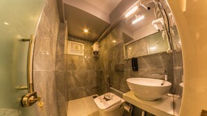 A modern bathroom with a large sink, a toilet, and a shower area. - Deluxe Room with Kitchen (Mumbai)