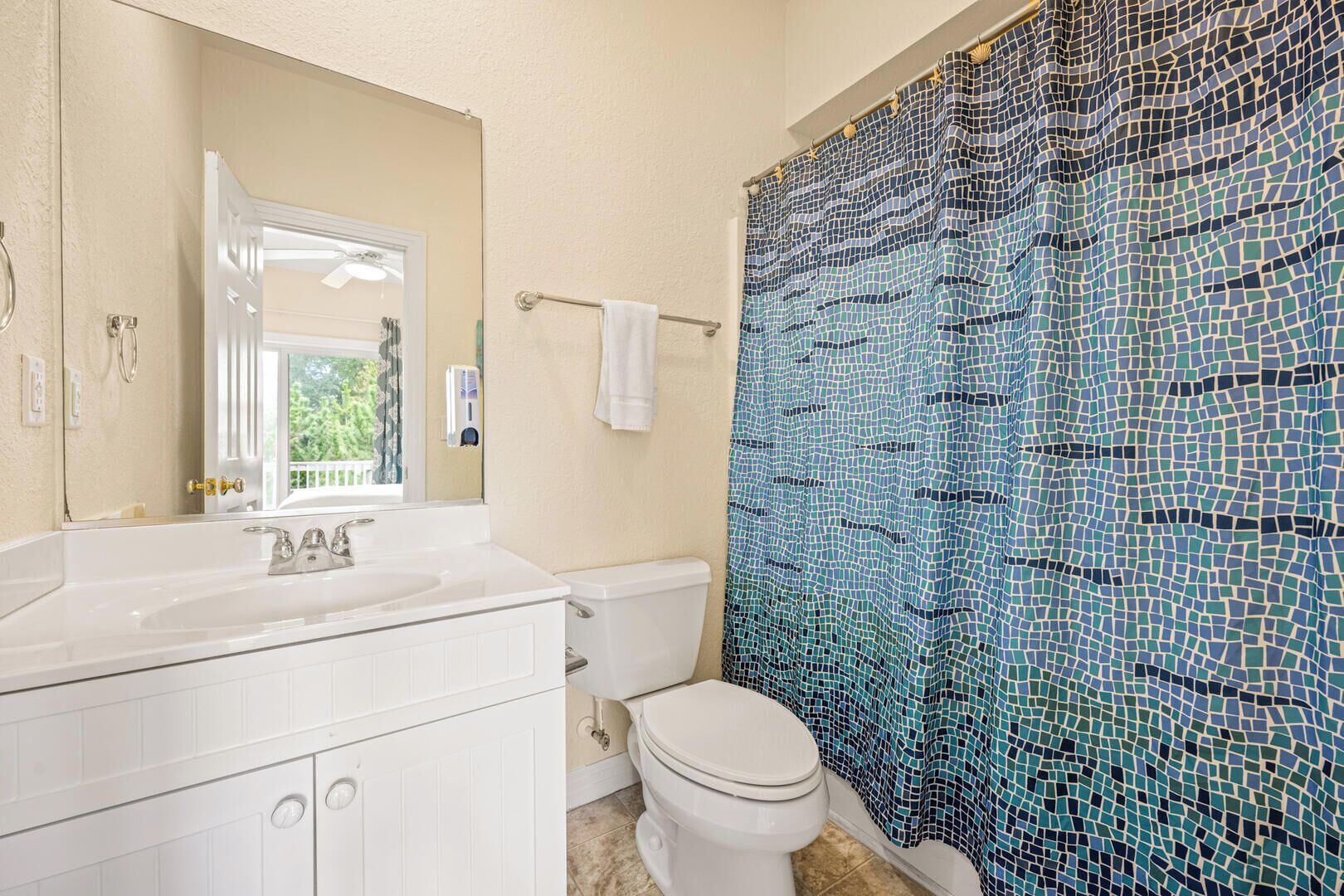 A bathroom with a white sink, mirror, and toilet.