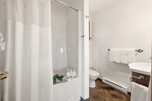 A bathroom with a shower, toilet, and sink.