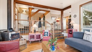 Una sala de estar acogedora con chimenea, una escalera y un comedor.