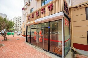 Un edificio con escaparate que tiene grandes ventanales y un letrero con letras rojas.