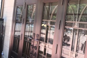 A building with large glass doors and windows reflecting outdoor scenery. - Hongrunde Hotel (Qingdao)