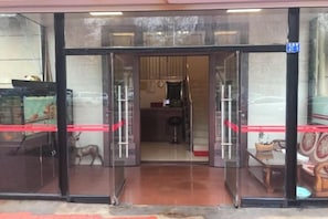 A hotel entrance with glass doors, a visible interior with furniture, and a red ribbon on the door. - Hongrunde Hotel (Qingdao)