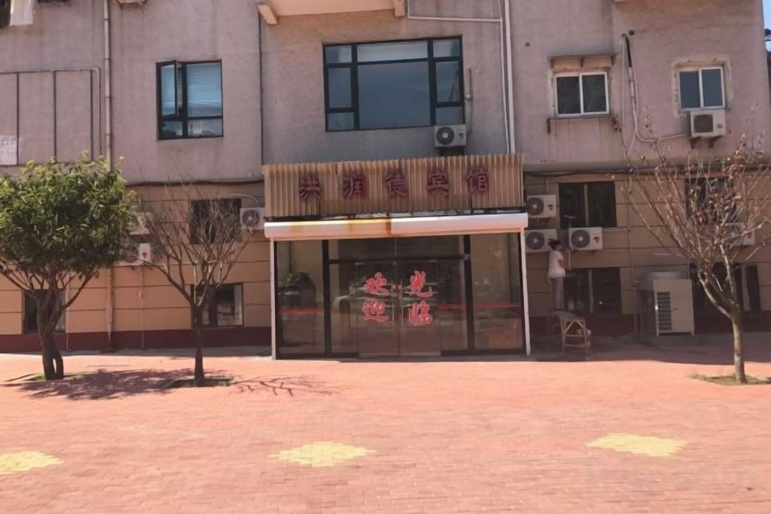 Een gebouw met een bord waarop 'Shenzhen Animal Hospital' staat en een overdekte ingang.