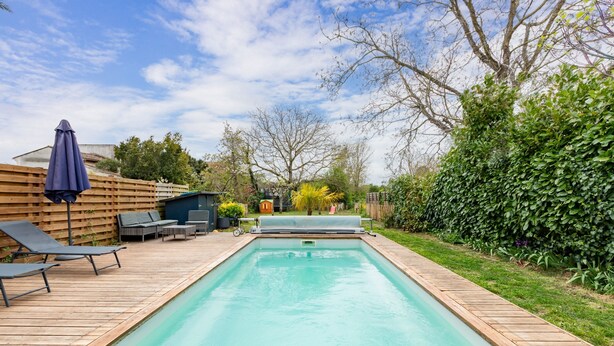 A rectangular swimming pool with a wooden deck, lounge chairs, and a covered umbrella. - L'Oasis De Calmont - Piscine Privée (Calmont)