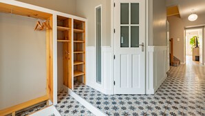 A hallway with a white door, a wooden wardrobe, and a tiled floor. - L'Oasis De Calmont - Piscine Privée (Calmont)
